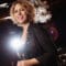 pianist and composer Gabriela Montero beams, with a chandelier and spotlight behind her