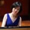 Jiao Sun seated at the piano in a blue dress