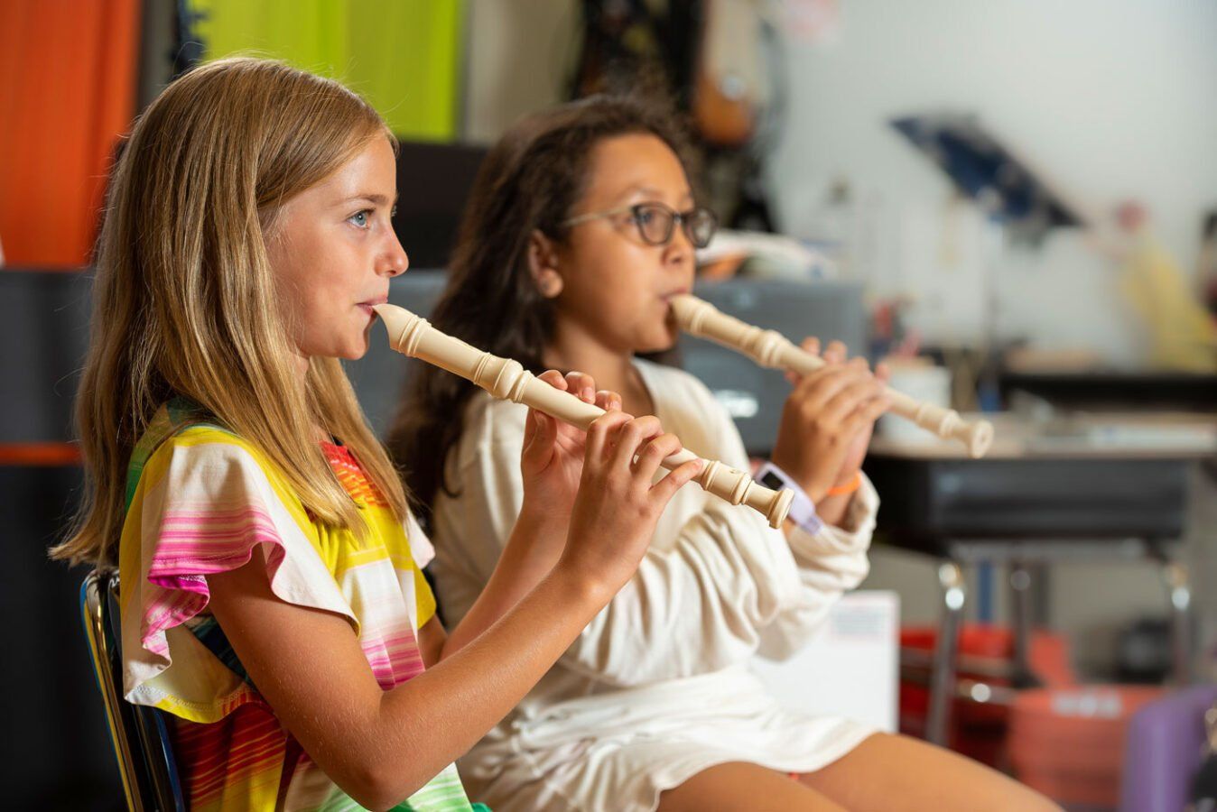 Two girls learning to play xylophones