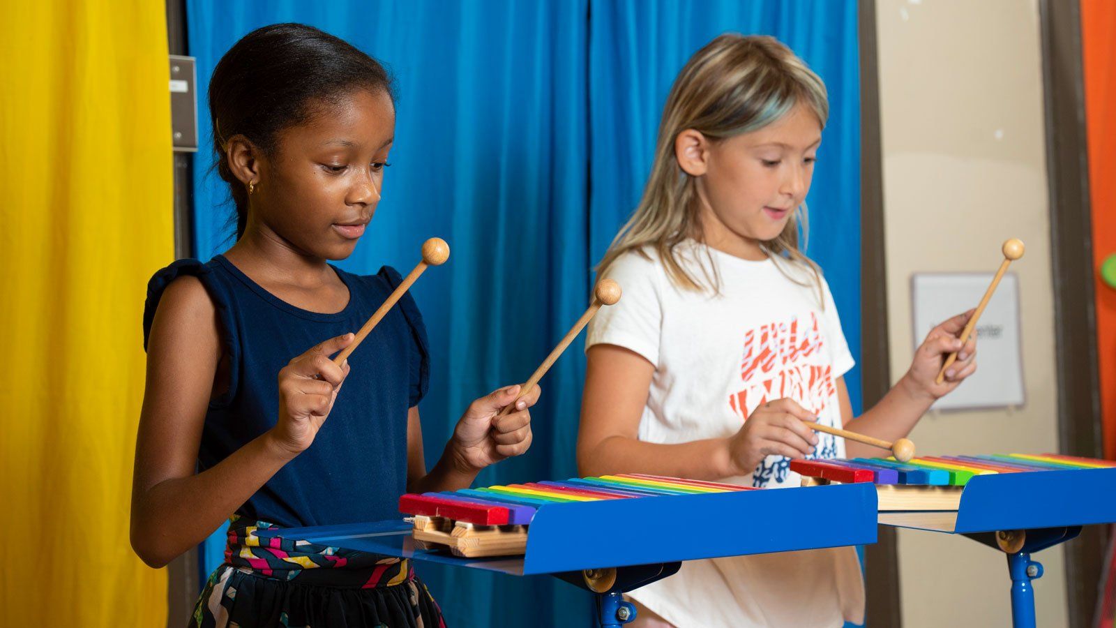 Two girls playing xylophones in music class