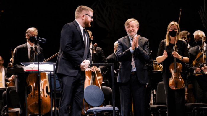 Andrew Davis applauding his son Ed Frazier Davis on stage with orchestra members