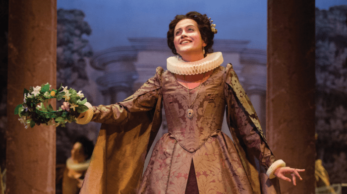 Amanda Forsythe in High Baroque costume holding a floral crown.