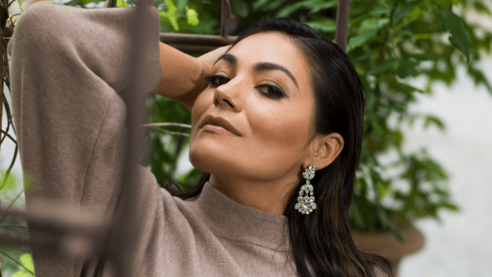 Portrait of Ailyn Pérez in profile, beige sweater dress, dramatic earrings
