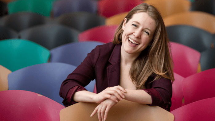 Gretchen Eng lauging, at Vassar College, in an auditorium with colorful seats.