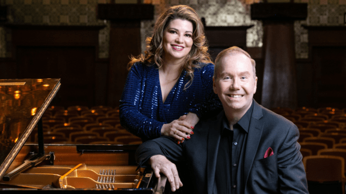 Portrait of Michelle Areyzaga leaning on piano with Dana Brown seated on piano bench