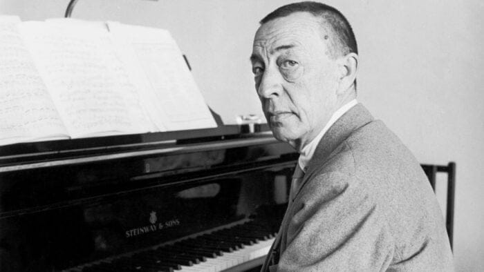 Sergei Rachmaninoff looks over his shoulder at the camera at the piano at Villa Senar