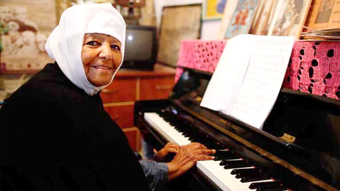 Emahoy Tsegué-Maryam Guèbrou seated at the piano