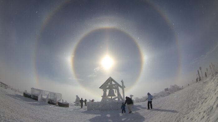 halo around sun in snow with belfry in foreground