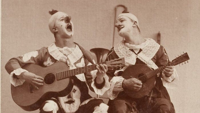 Two folk singers in clown costumes