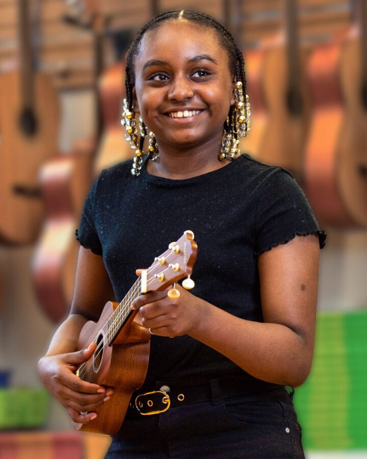 Girl in music class learning to play ukelele