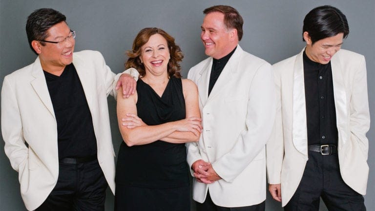 The Miami String Quartet, clad in black and white formalwear, share a laugh