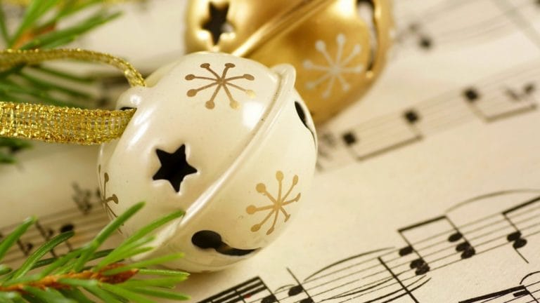holiday image: a bell with sheet music and pine needles