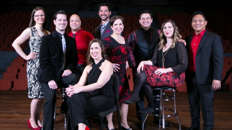 Chicago a cappella, dressed semiformally in red and black, poses onstage