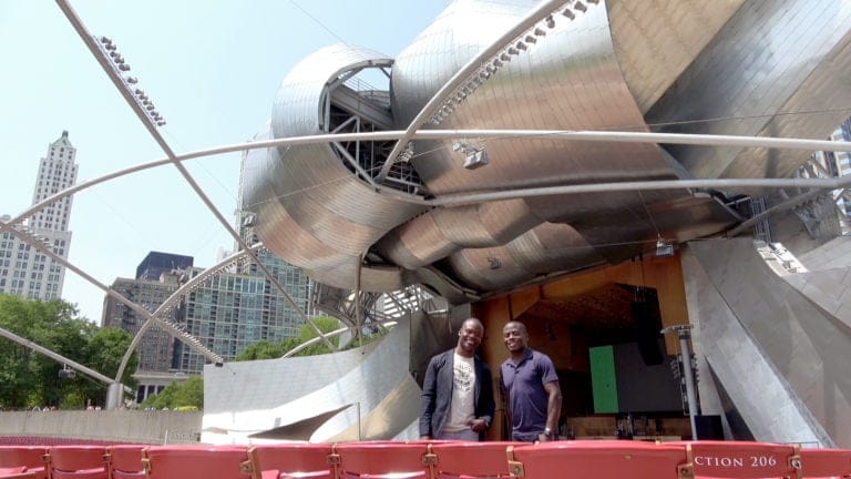 the mcgill brothers pose in front of the strikingly modern pritzker pavilion in millennium park