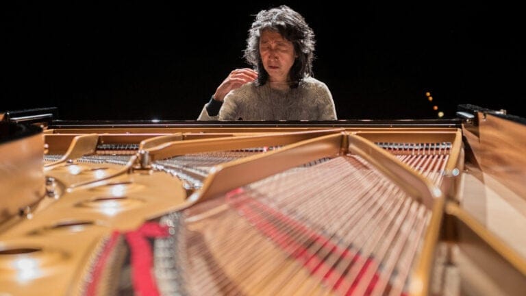 Mitsuko Uchida entranced, at the piano