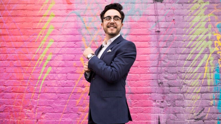 Julian Velasco in front of a bright, multicolored wall
