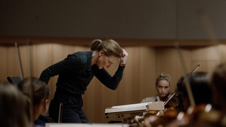 Still from TÁR (2022): Tár rehearses music newly admitted orchestra cellist Olga Metkina