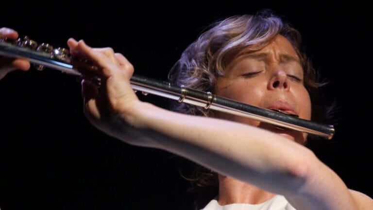 Claire Chase, absorbed in performance, plays the flute