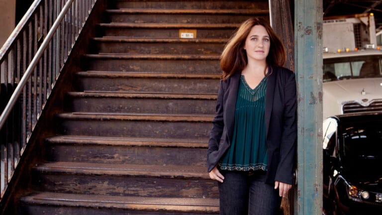 Pianist Simone Dinnerstein poses at a staircase in a city