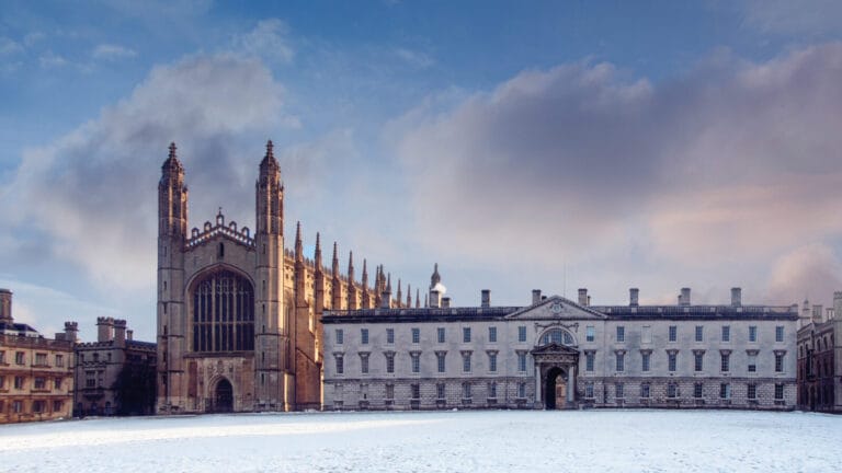a wintry view of the King's College Chapel, an ornate gothic chapel seated in front of a snowy field