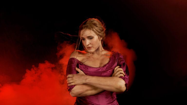 Lise Davidsen in a tattered red dress in front of red smoke