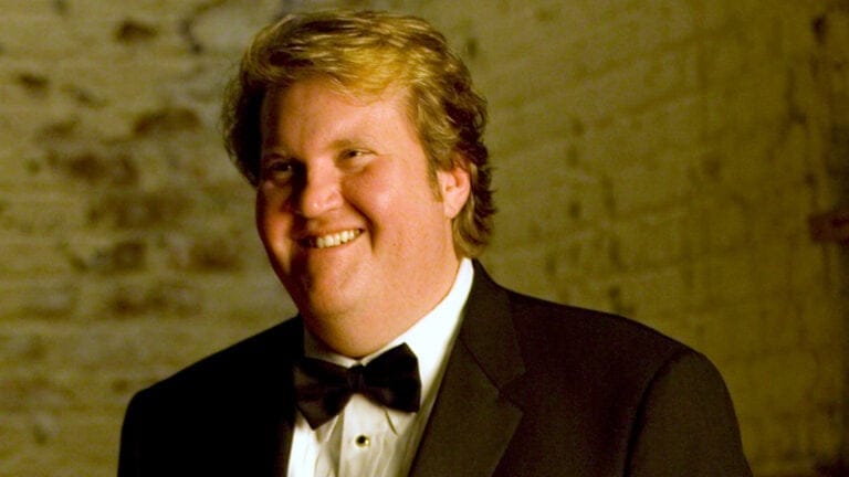 Tenor Anthony Dean Griffey in a tux in front of a rustic brick wall