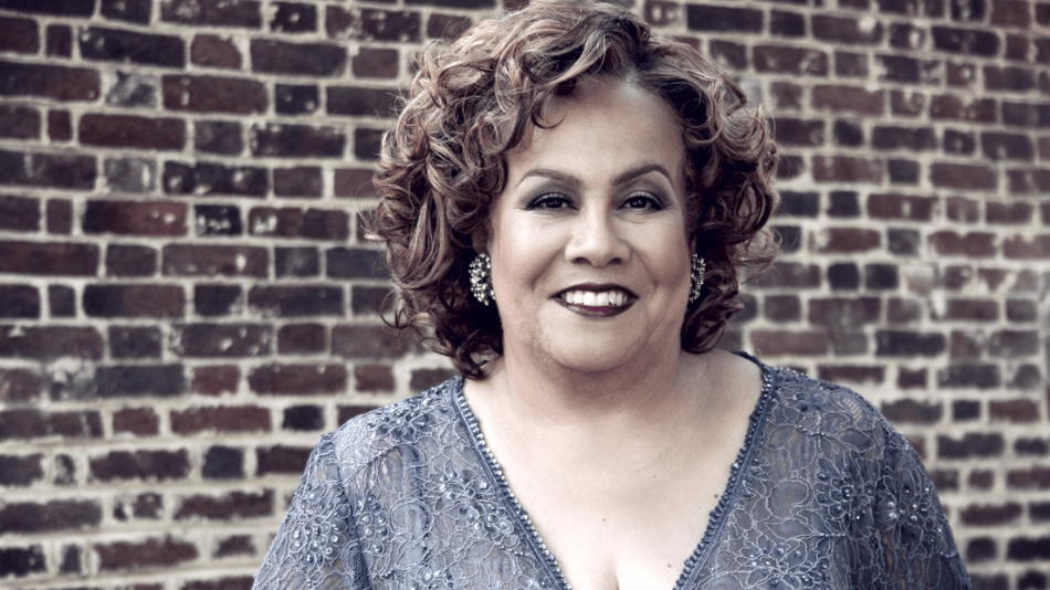 Portrait of Louise Toppin in front of red brick wall