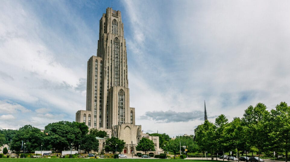 The striking Cathedral of Learning in Pittsburgh stands apart, against a slightly cloudy sky, on the University of Pittsburgh campus