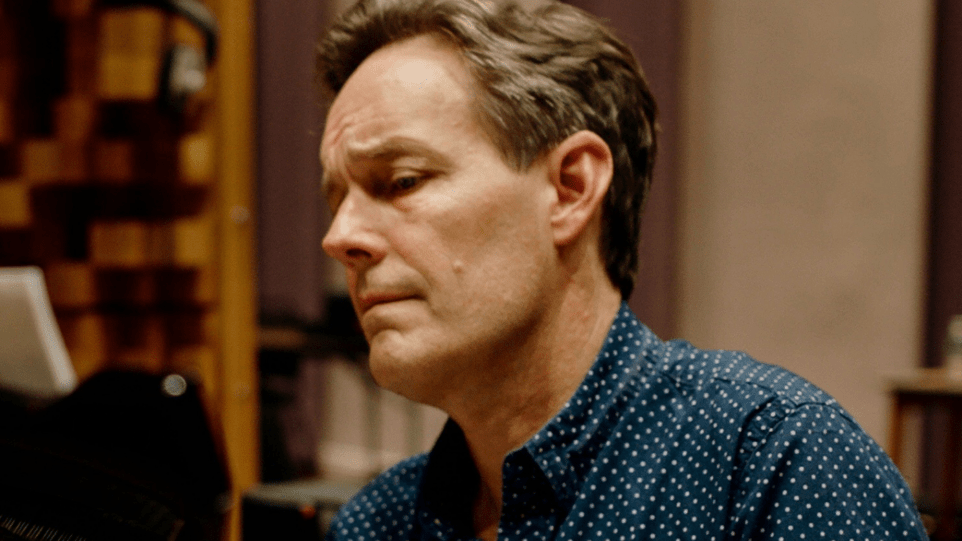 Jake Heggie portrait with furrowed brow at the piano.