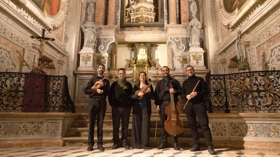 Iberian Ensemble poses together with their instruments in a cathedral