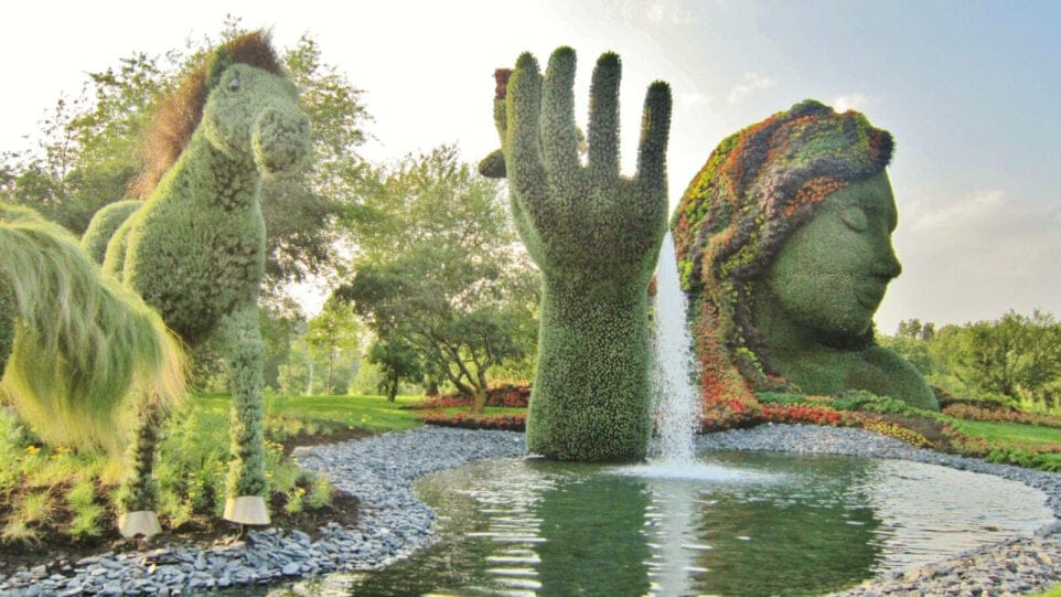 topiary animals, mother natures head and hand in a pool