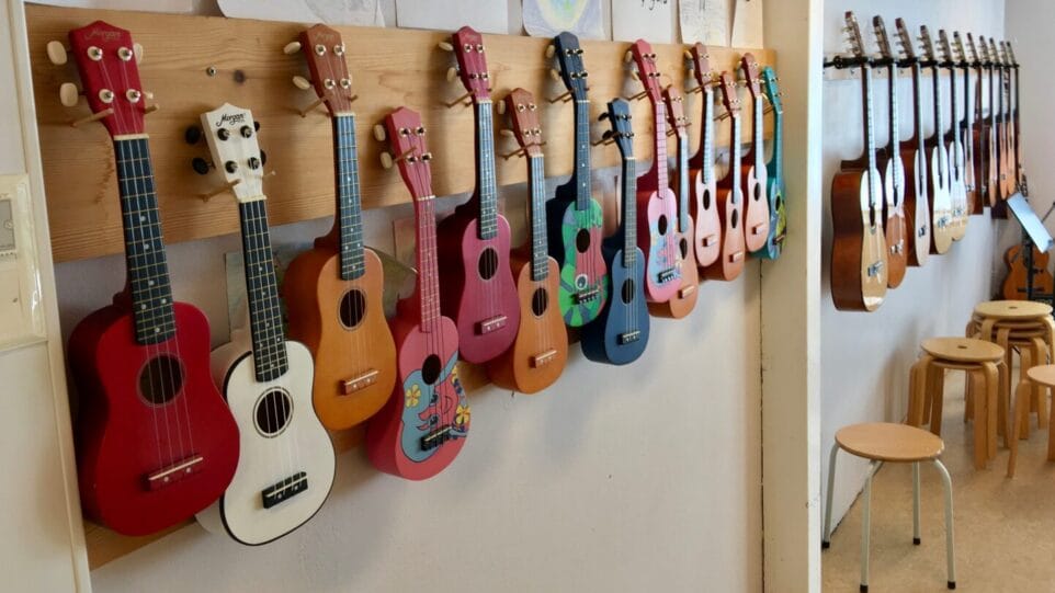 children's ukuleles hang on pegs in schoolroom