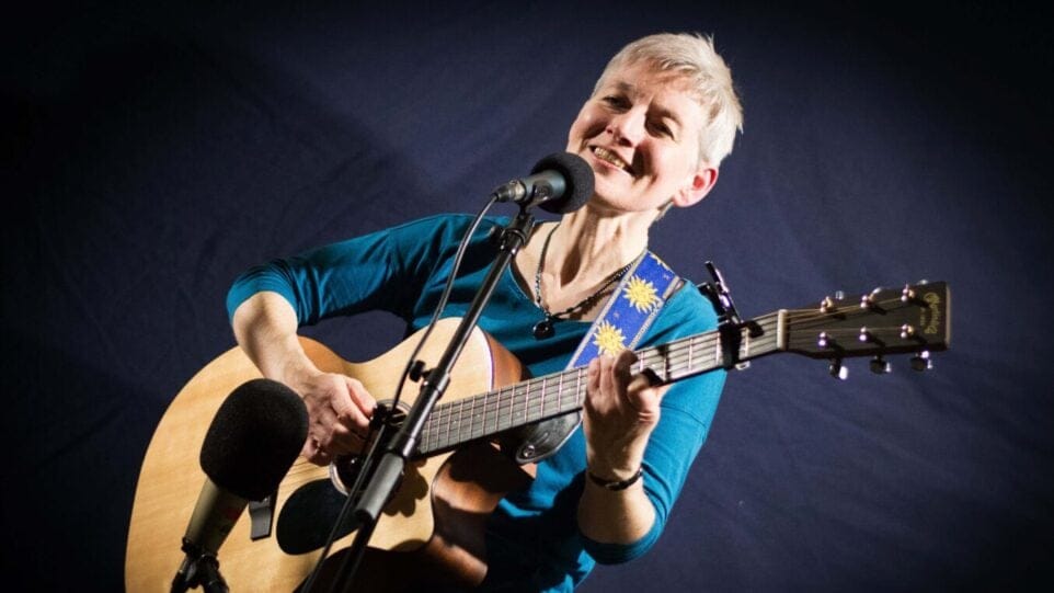 Smiling woman plays guitar