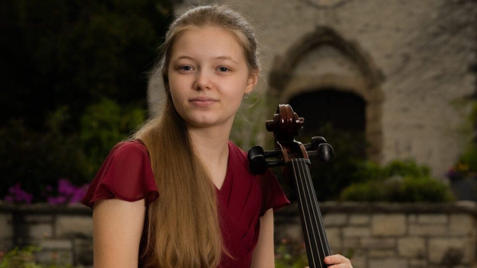 Amelia Zitoun holds cello in courtyard