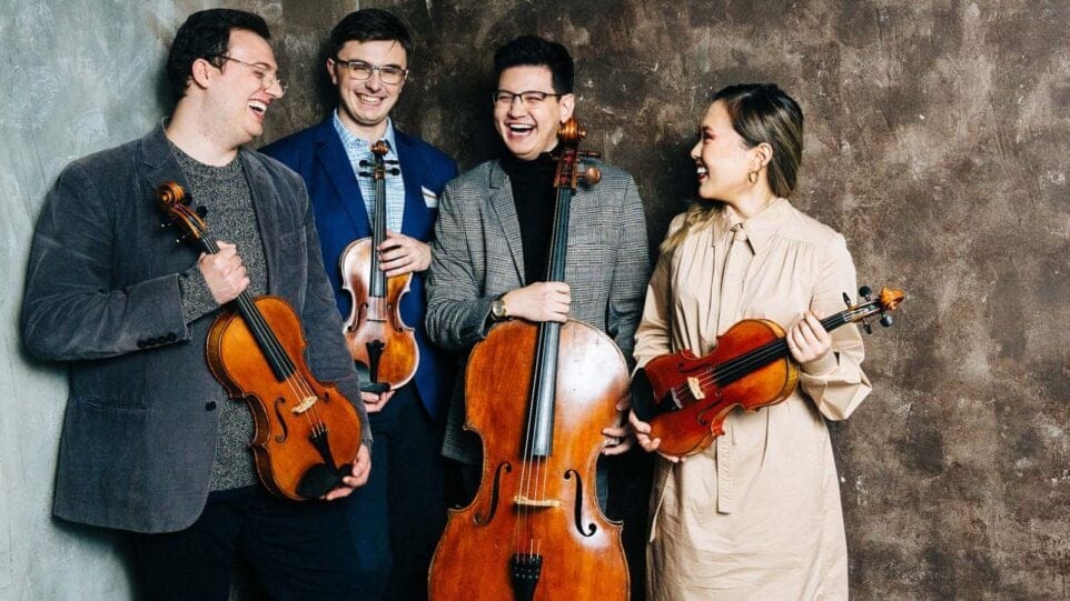 The members of Balourdet Quartet share a laugh holding their instruments