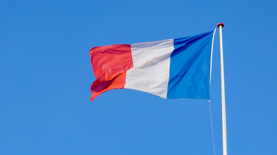 French Flag blowing in the wind. with a blue sky background