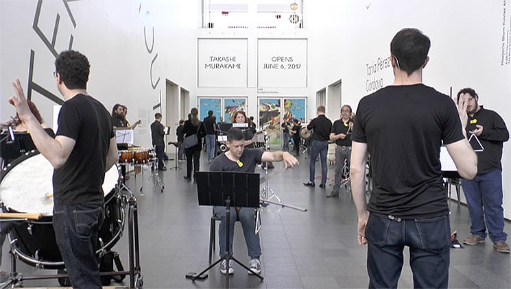 musicians playing percussion instruments in a museum hallway