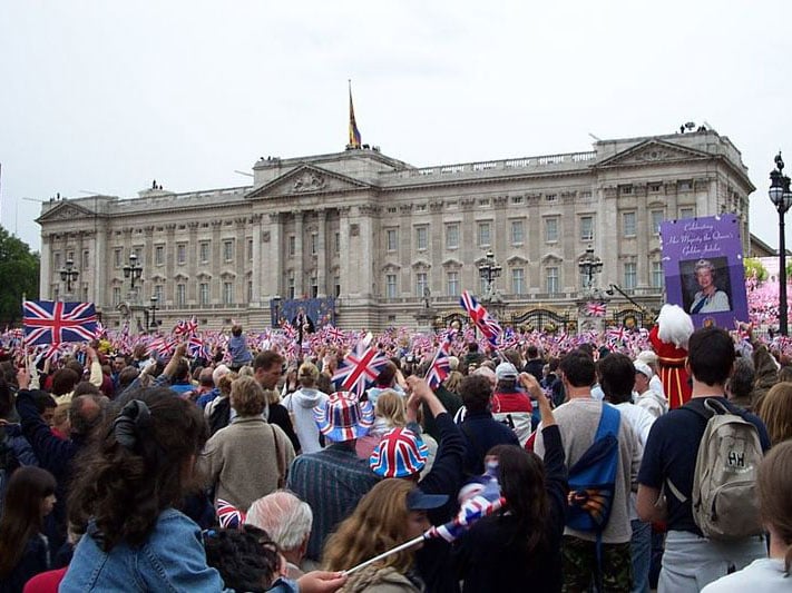 People wave their flags outside Buckingham Palace, 4 June 2002