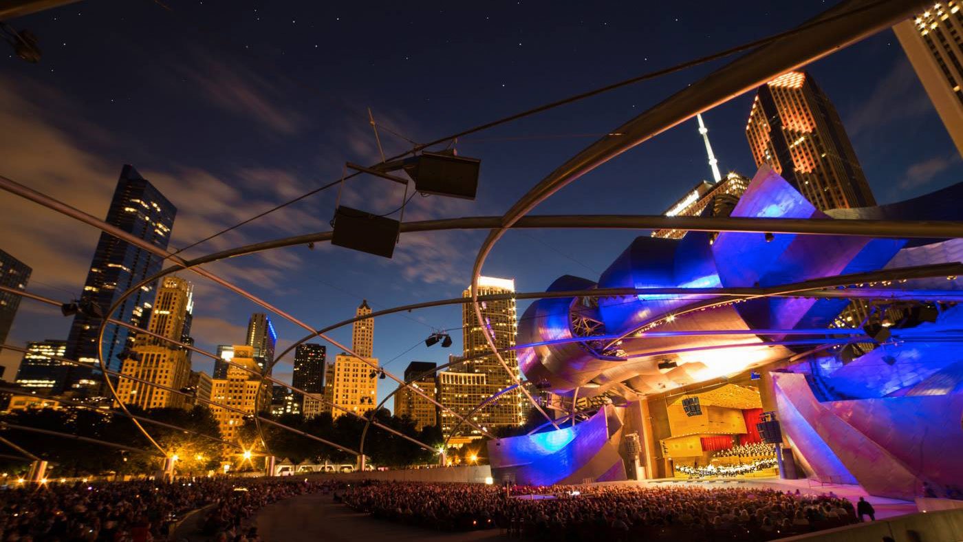 the striking Jay Pritzker Pavilion of Millennium Park is lit up during a nighttime Grant Park Music Festival performance