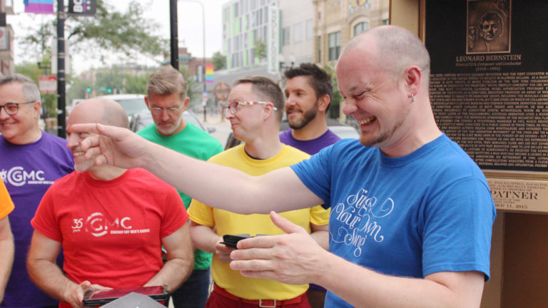 Members of the Chicago Gay Men's Chorus and Artistic Director Jimmy Morehead share a moment at the Leonard Bernstein memorial plaque on the Legacy Walk for WFMT Bernstein 100 Celebration