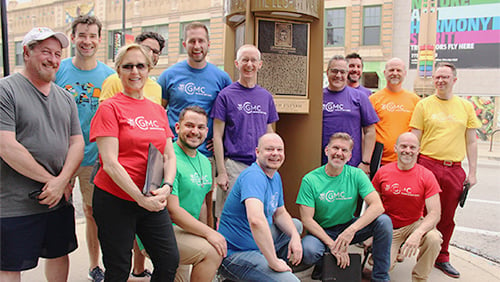 Legacy Project founder and executive director Victor Salvo; WFMT host David Polk; members of the Chicago Gay Men's Chorus; and CGMC artistic director Jimmy Morehead pose with Leonard Bernstein's memorial plaque.  WFMT Bernstein 100 Celebration