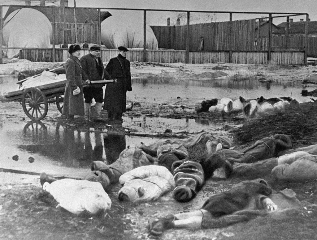 Three men burying victims of Leningrad’s siege. The Volkovo cemetery. October 1, 1942.