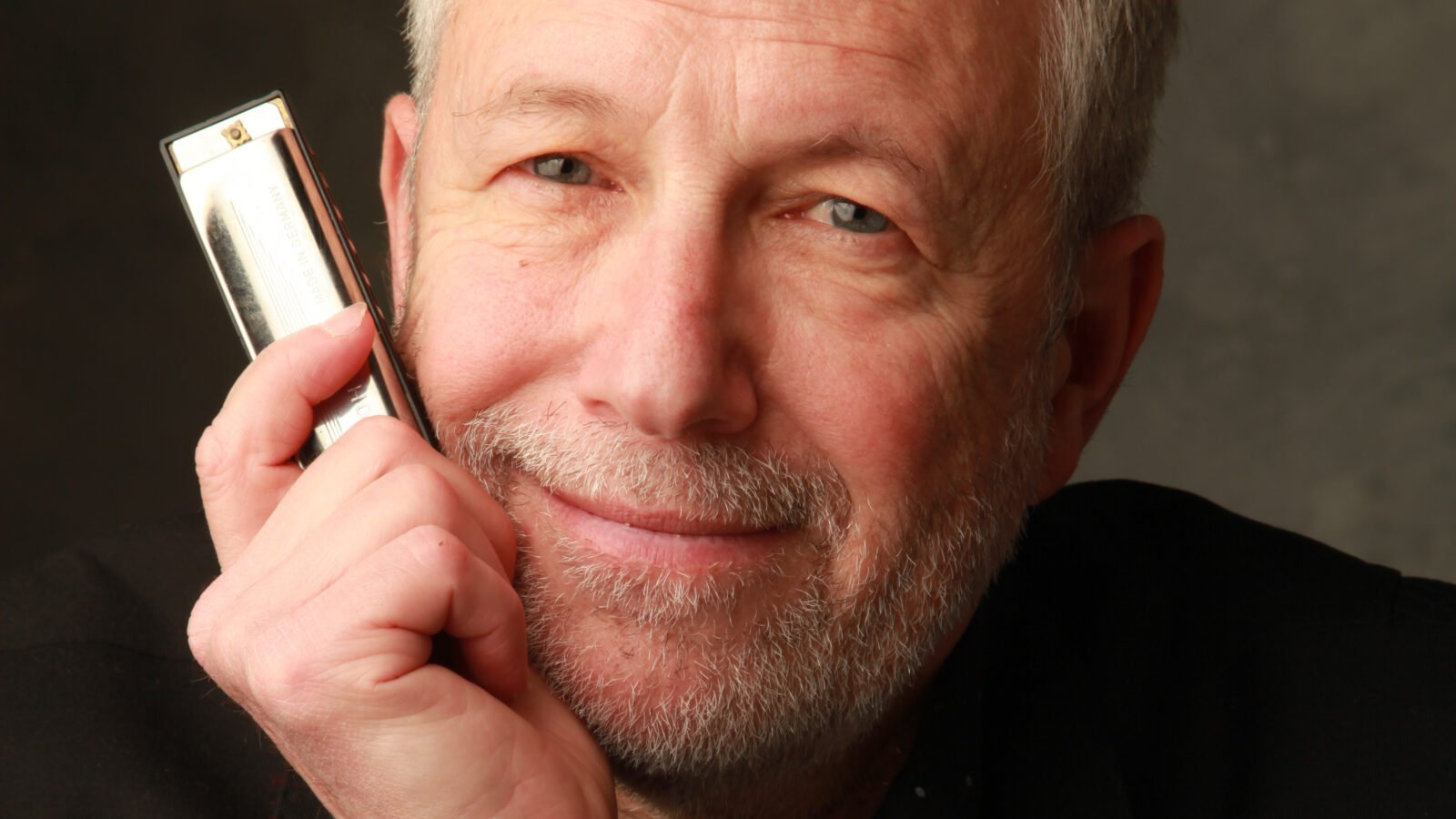 Corky Siegel holds a harmonica