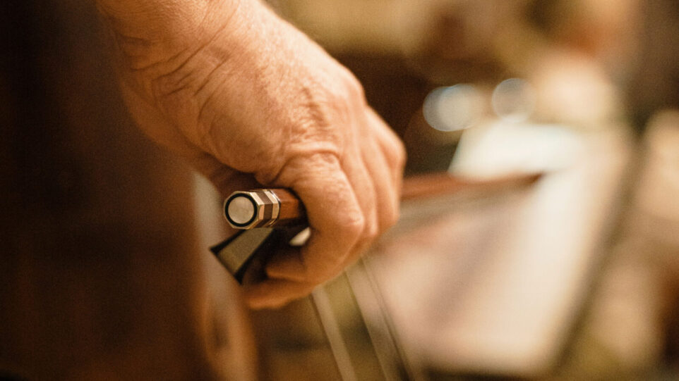 A bow on the strings of an upright instrument