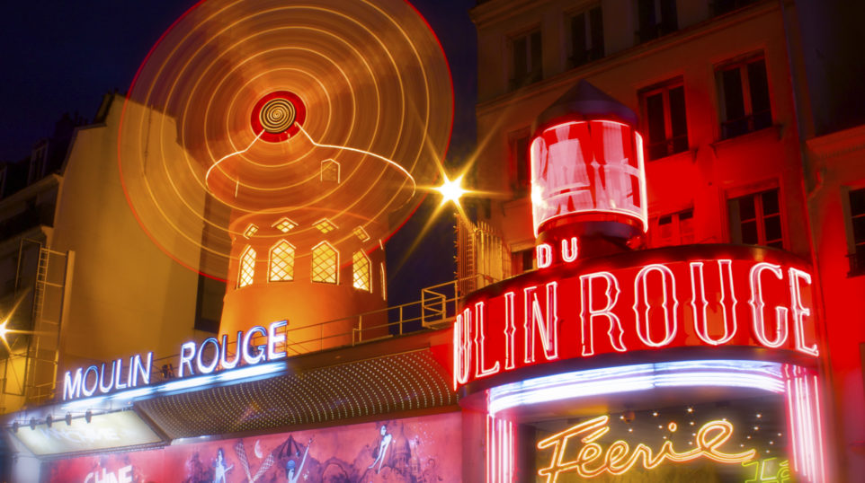 spinning windmills cast in neon lights in French scene