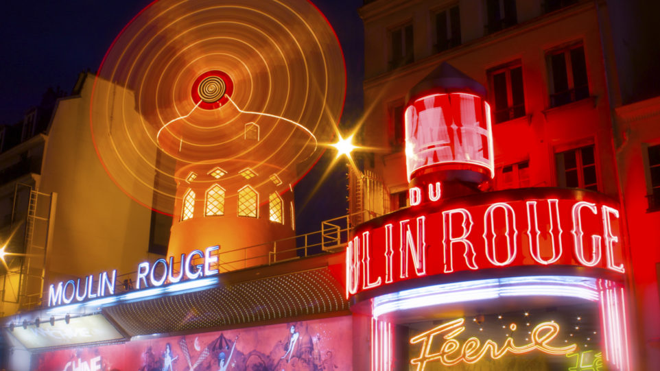 spinning windmills cast in neon lights in French scene