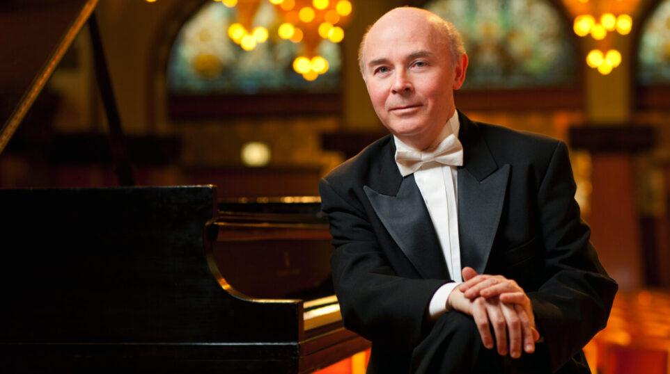 Jorge Federico Osorio with a piano in a well lit historic room