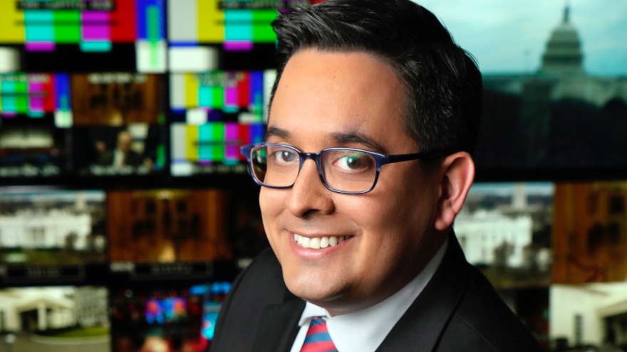 Portrait of Ed O'Keefe in a newsroom with monitors