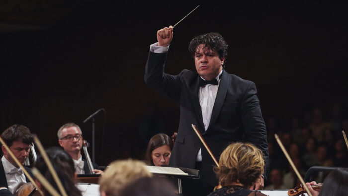 Cristian Măcelaru waves a baton to conduct the orchestra