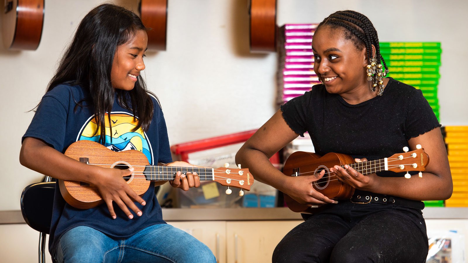 Two girls playing recorders and paying attention to music teacher